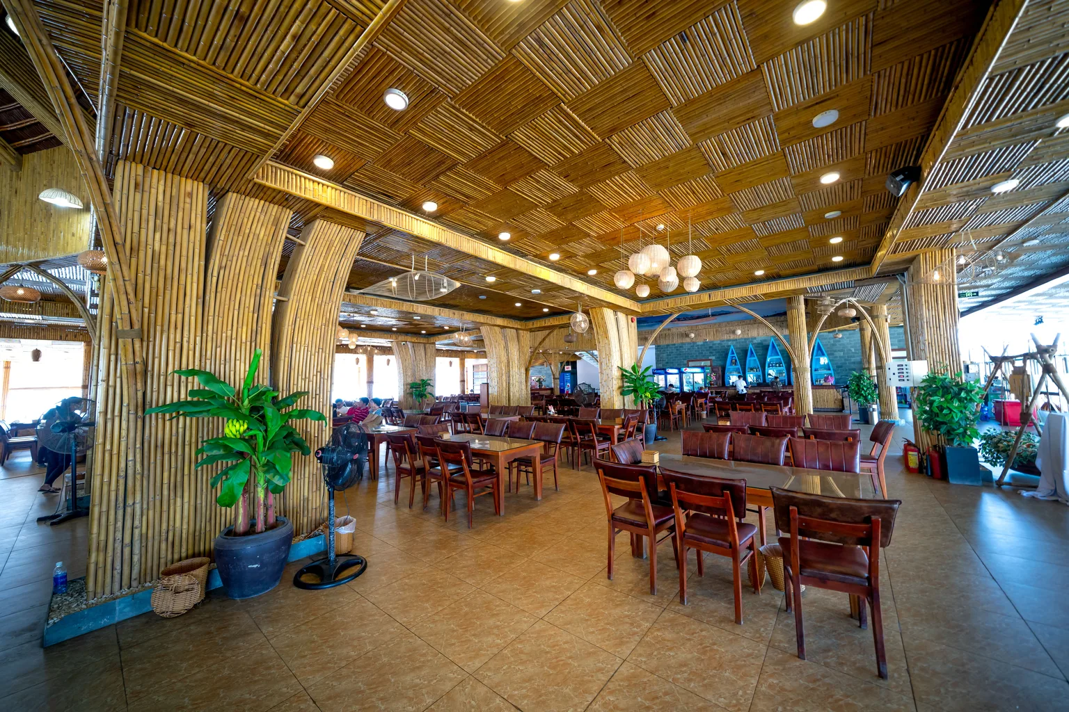 Wooden tables and chairs arranged in a warmly lit restaurant dining room