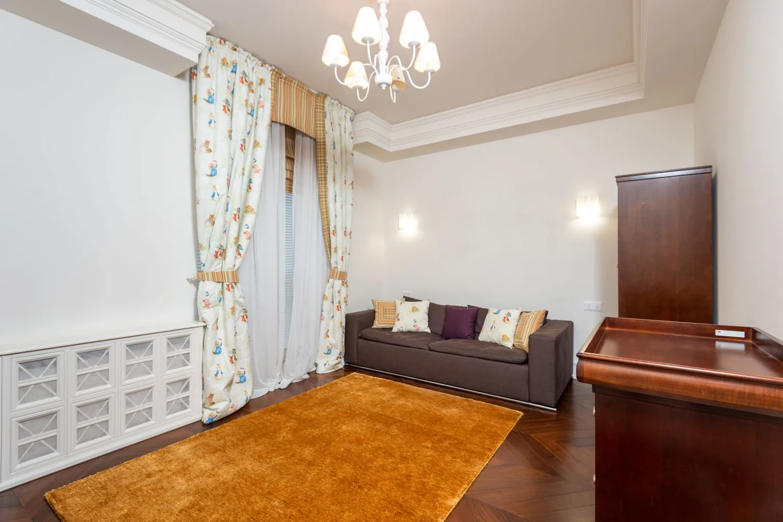 A spacious living room with a chandelier and carpeted floor