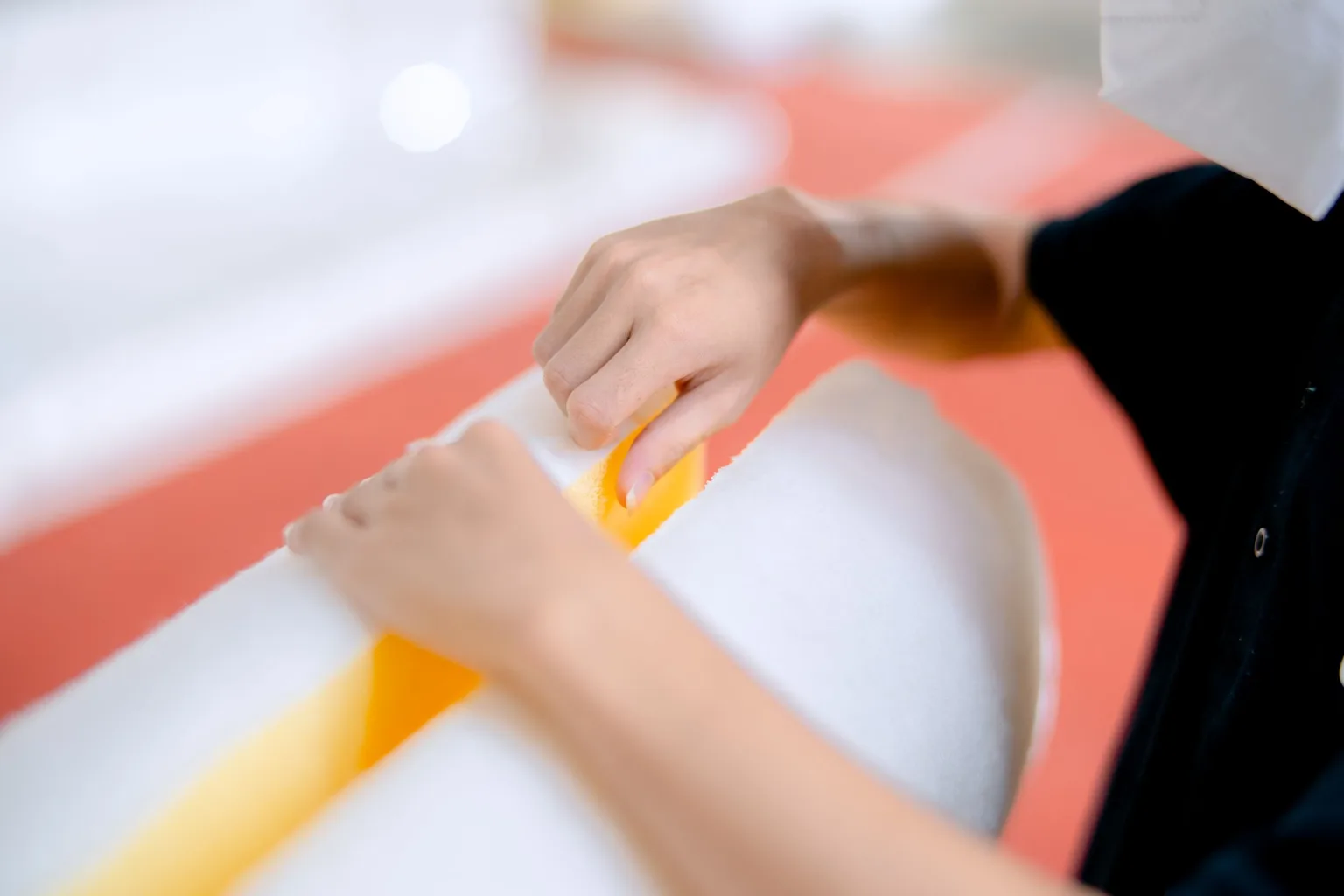 Hands working with polyurethane foam padding material