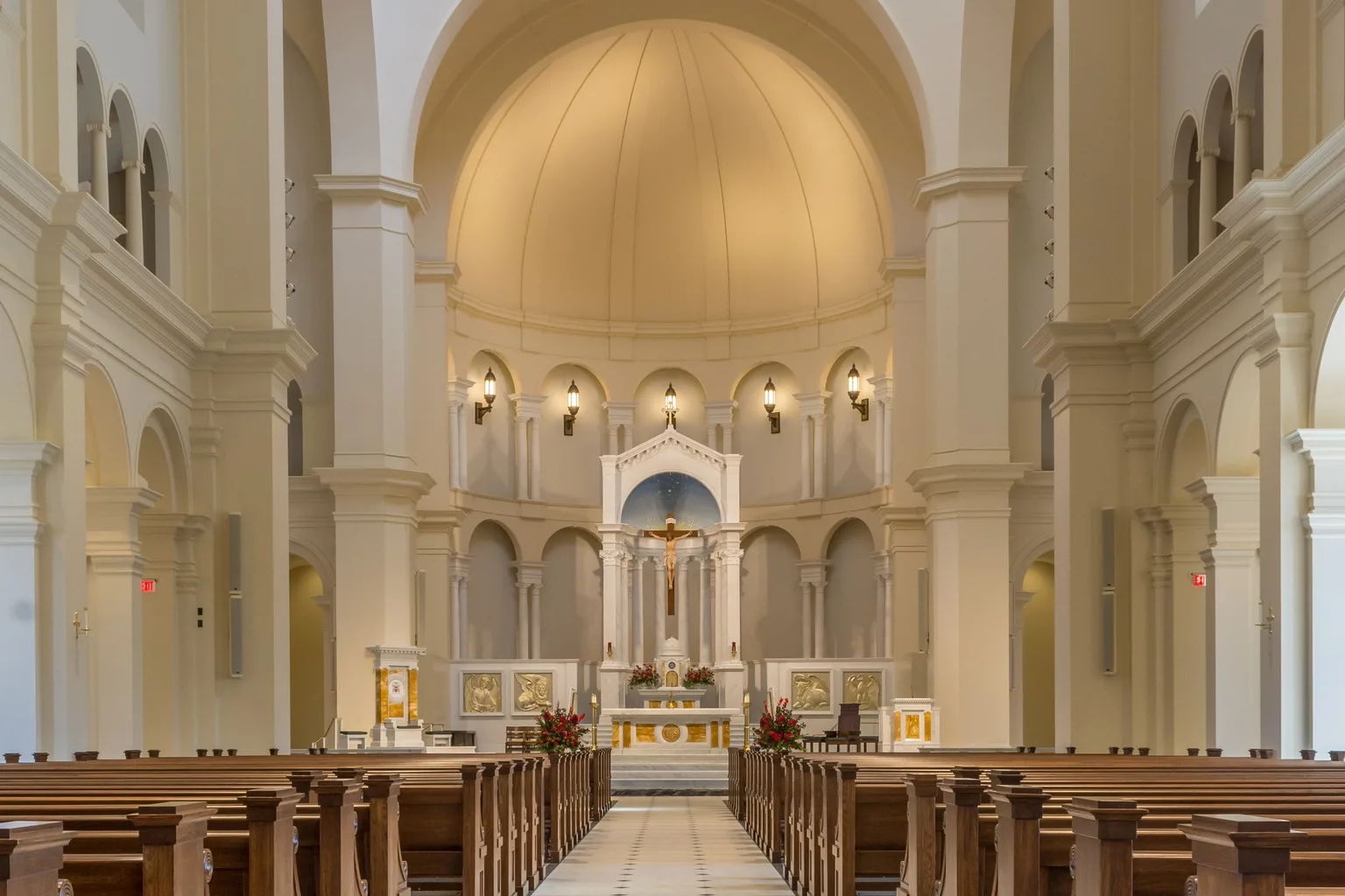 The aisle inside a cathedral with wooden pews