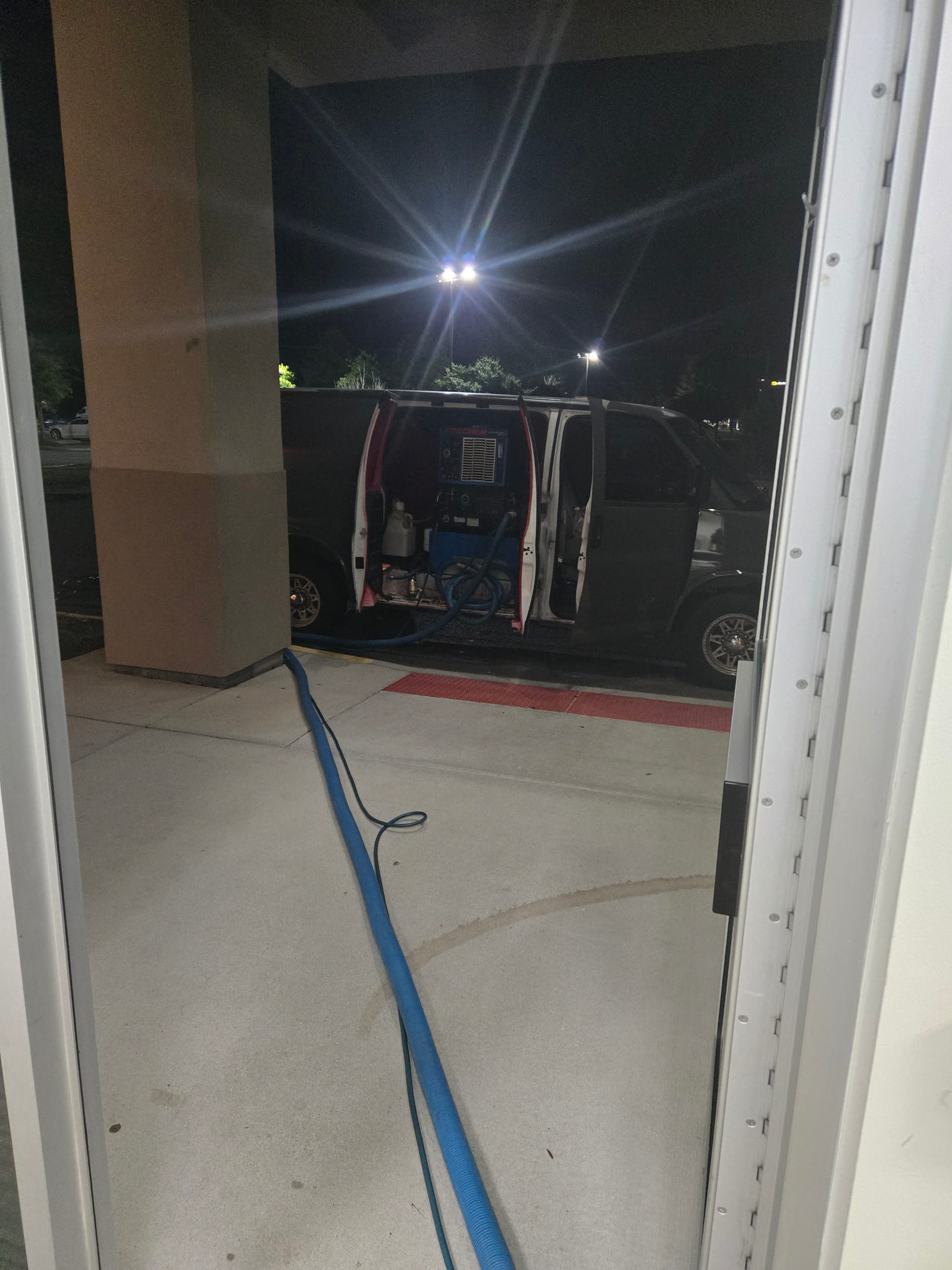 All City truck-mount carpet cleaning van set up outside a commercial doorway at night